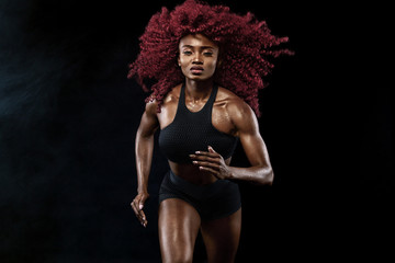 A strong athletic, female sprinter, running at sunrise wearing in the sportswear, fitness and sport motivation concept with copy space.