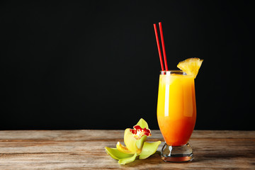 Poster - Glass of Sex on the Beach cocktail on wooden table against dark background