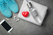 © Africa Studio - Gym stuff, phone and red heart on grey background. Cardio training concept