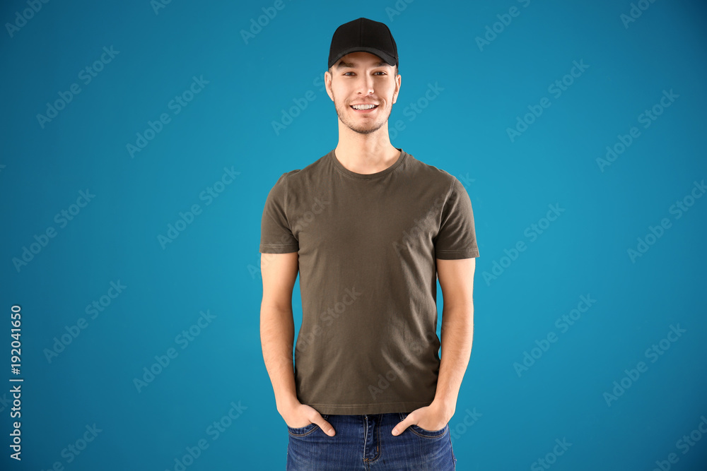 Young man in stylish t-shirt on color background. Mockup for design