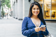 © Inti St Clair/Blend Images - Close up of Hispanic woman texting on cell phone in city