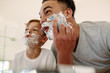 Funny father and son shaving in bathroom