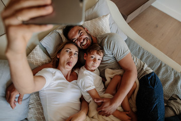 Wall Mural - Crazy family on bed taking selfie