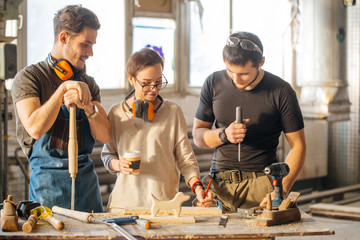 Wall Mural - male Carpenter Training Female Apprentice To Use Plane