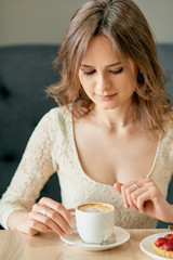 Wall Mural - Young beautiful woman drinks morning coffee in cafe