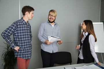 3 people work in the office, talking to, and address the issues of the company, smile and sign documents