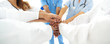 © ASDF - Doctors and nurses in a medical team stacking hands