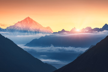 Wall Mural - majestic scene of silhouettes of mountains and low clouds at colorful sunrise in nepal. landscape wi