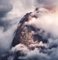 Wall Mural - Majestical mountains in clouds in overcast evening in Nepal. Landscape with beautiful high rocks and dramatic cloudy sky with sunlight at sunset. Nature background. Fairy scene. Amazing mountains