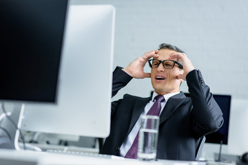 Wall Mural - stressed businessman looking at computer screen at workplace