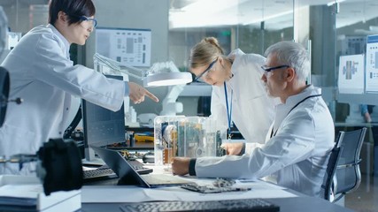 Wall Mural - team of scientists choose between printed circuit board to work with. in the background technologica