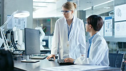 Wall Mural - asian scientist sitting at his desk consults senior engineer about sophisticated coding and programm