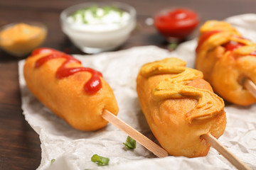 Poster - Tasty corn dogs with sauces on table