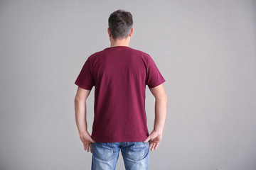 Wall Mural - Man in color t-shirt on light background. Mockup for design