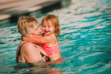 Grandmother And Granddaughter Swimming At Pool