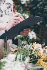 Poster - Florist writing various information on the tablet on flower shop