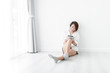 © nuiiko - Beautiful woman wearing white shirt and using tablet on floor, copy space.