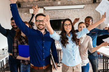 Group of successful young architects posing in office