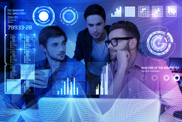 Thint it out. Professional young IT men sitting at the table and coding while working at night
