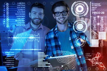 new program in use. cheerful professional it men touching a transparent screen while being involved 