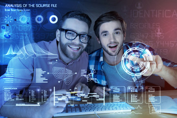 Identification profile. Cheerful young programmers working at night while developing new security program