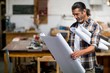© Wavebreak Media - Carpenter looking at a blueprint