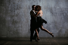 Young Pretty Woman In Black Dress And Man Dance Tango