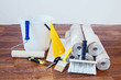 Composition with many rolls of wallpaper and various tools for home repair