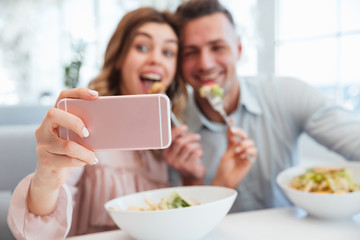 Wall Mural - Portrait of an excited young couple taking a selfie