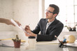 © merla - Businessman signing some document, sitting on his office desk