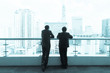 Two businessman talking on a roof and looking at city