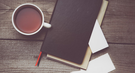 Blank business cards with pen, notebook and tea cup on wooden office table