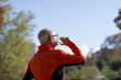 © 2Design - Senior runner drinking water after jogging