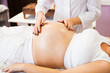 © yatcenko - Young pregnant woman having abdominal massage at beauty spa salon. Close-up.  Spa treatment