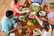 © Syda Productions - group of people eating at table with food