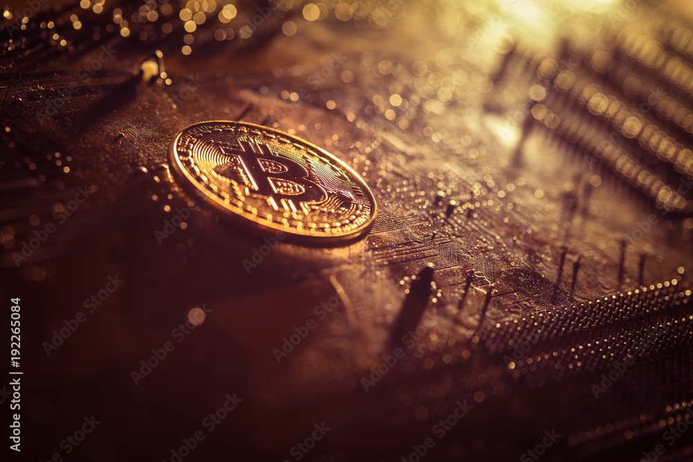 Golden bitcoin token lying on a computer motherboard 