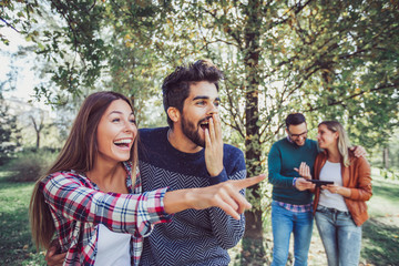 Wall Mural - Group of smiling friends outdoors in park, having fun.