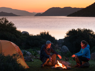 Wall Mural - couple camping with campfire and tent outdoors