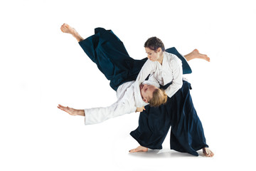 Man and woman fighting at Aikido training in martial arts school