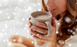 © Syda Productions - close up of happy woman with cup of cocoa at home