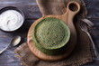 Spinach pancakes with sour cream on a wooden board, rustic style, selective focus