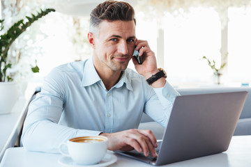 Canvas Print - Portrait of a smiling mature man talking on mobile phone