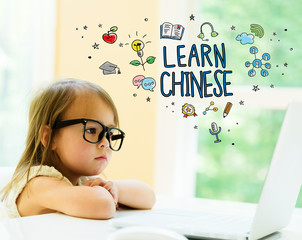 Wall Mural - Learn Chinese text with little girl using her laptop