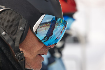 Wall Mural - Ski goggles on a white winter landscape. Blue reflection