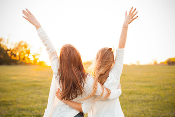 young women are having fun on the green field in the evening.