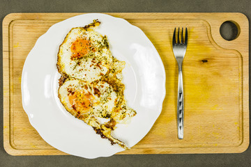 Fried egg with spices on a plate.