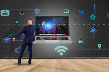 Poster - Businessman in front of a wall with a computer surrounding by app and social icon - 3d render