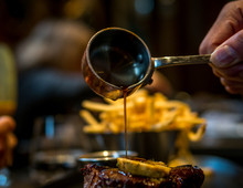 Pouring Au Jus Over A Steak