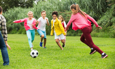 Wall Mural - Kids playing football in park