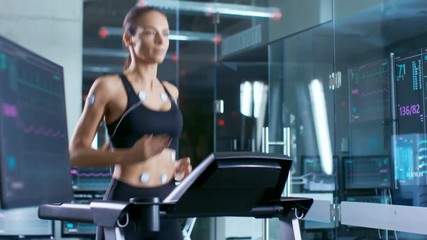 Wall Mural - beautiful woman athlete runs on a treadmill with electrodes attached to her body, female physician u